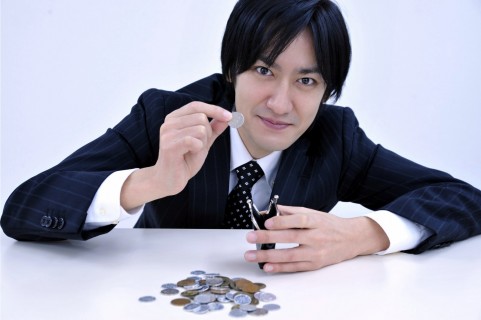 値段相応のサービスに期待! 小銭を持っている男の人の写真