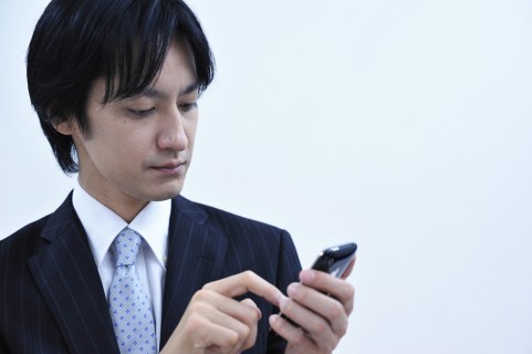 スマホを見る男の人の写真