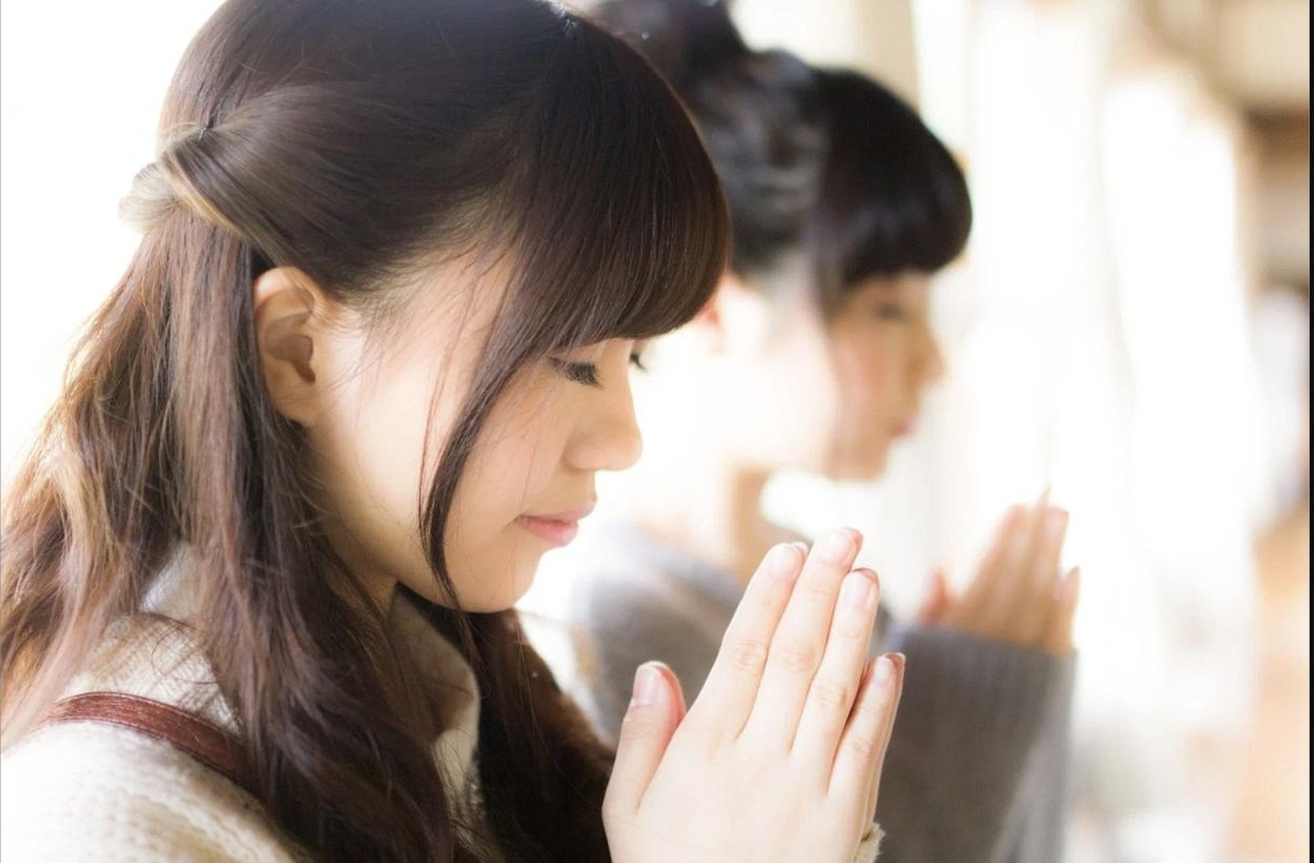 両手を合わせて合格祈願をする受験生