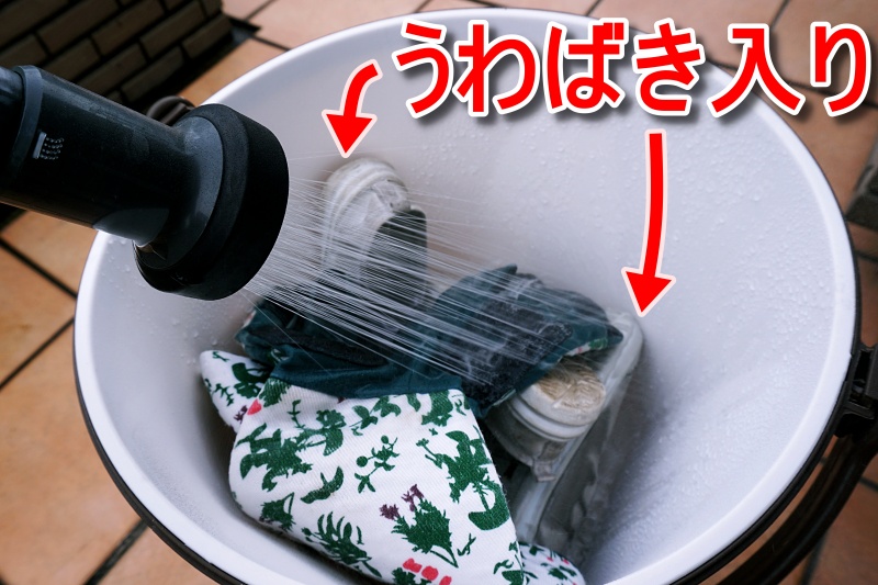 泥がついたガーデニング手袋と上履きをバケツ型洗濯機に入れた状態