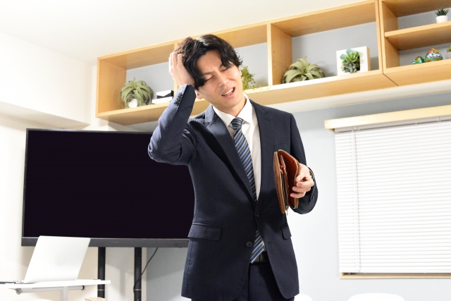 ITエンジニアの男性が経済的に苦しくて財布をチェックしたらお金がなくて悩んでいる様子
