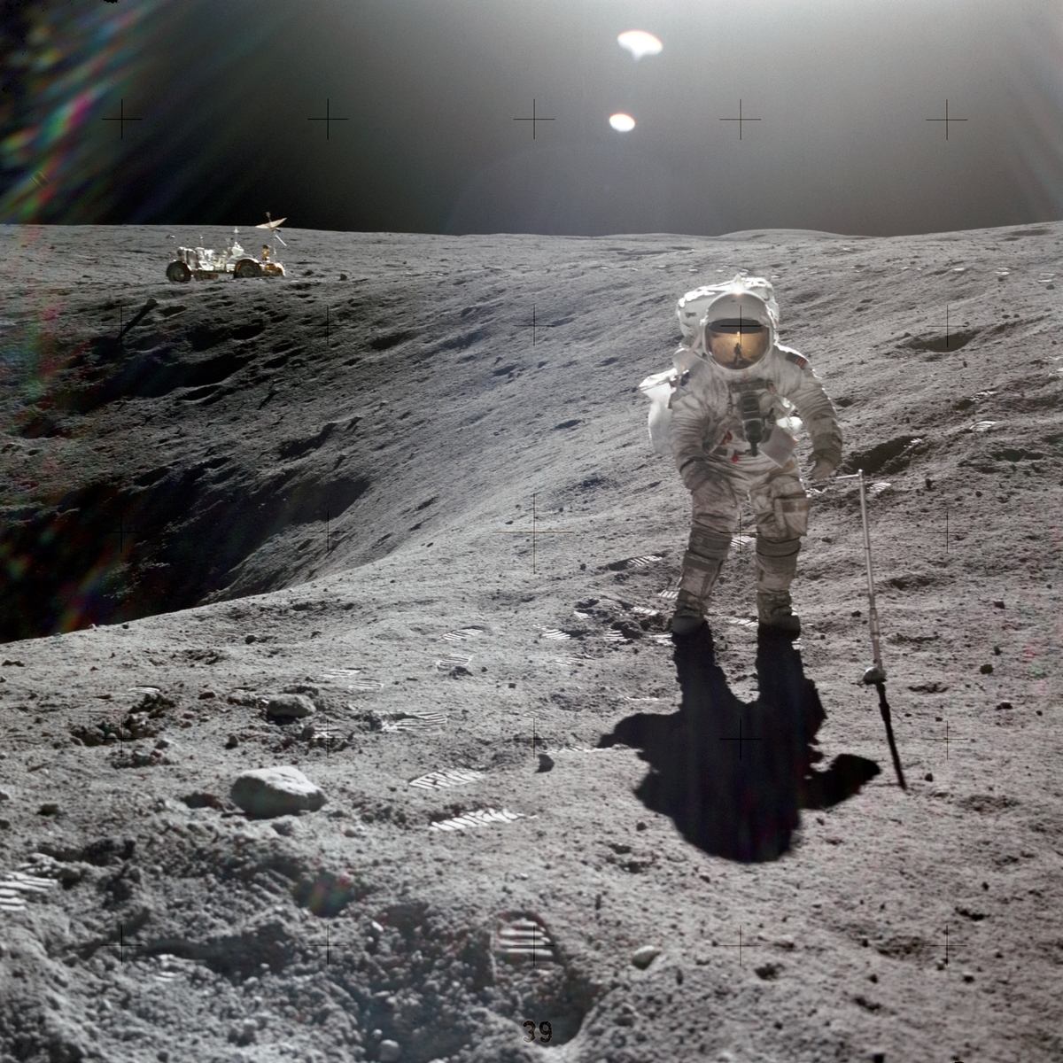 月面のクレーターの側に立つアポロ16号の宇宙飛行士
