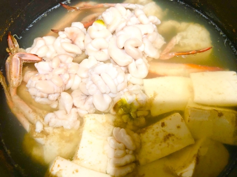 白子とワタリガニと豆腐を煮ているところを撮った写真