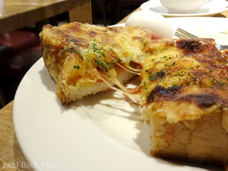 ピザトーストの断面に伸びるチーズ