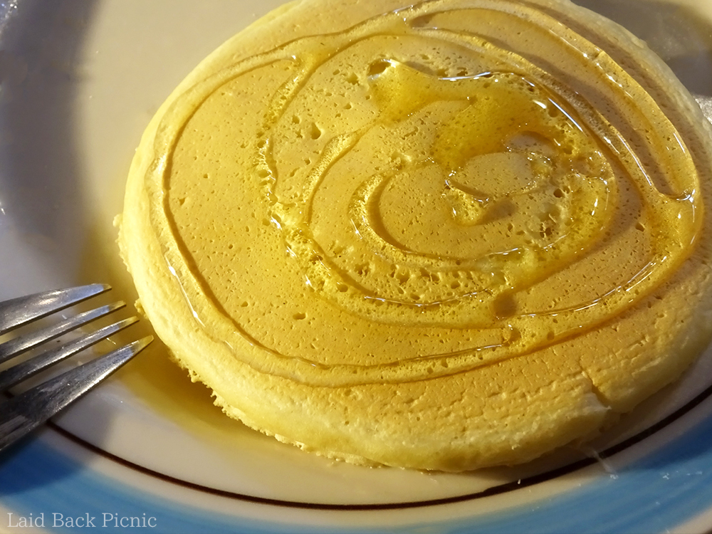ふわふわのパンケーキの上で輝くハチミツ