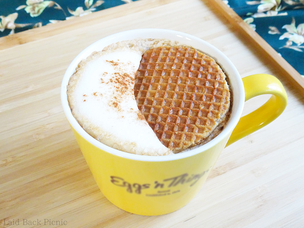 カプチーノの泡の下に沈んでいくストロープワッフル