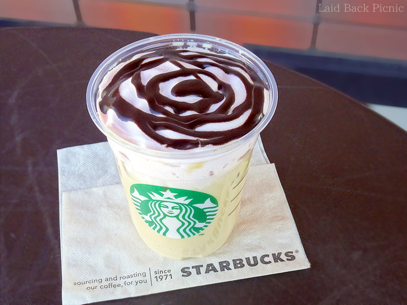 ピンクムースの上にチョコソースがぐるぐるとかけられている