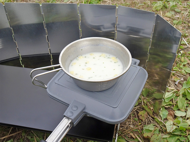 ホットサンドメーカーでパンを焼きながら、上にスープ入りシェラカップ