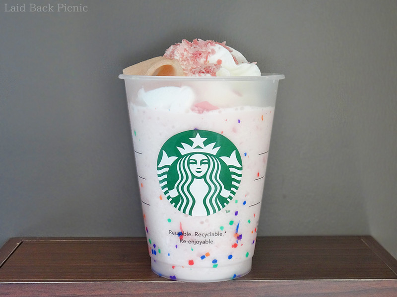 薄いピンク色のフラペチーノにホイップとピンク色のチョコ、生八ッ橋のトッピング