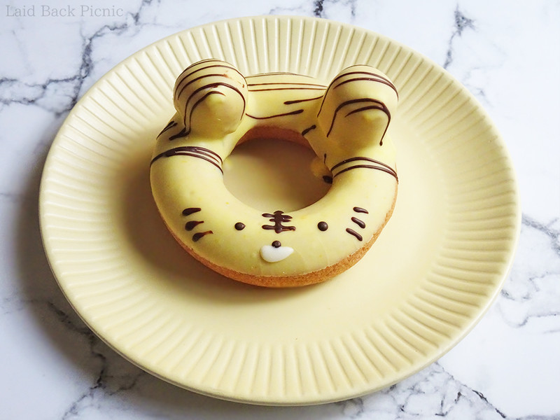丸いドーナツに黄色いチョコがけ虎の顔がチョコで書かれている