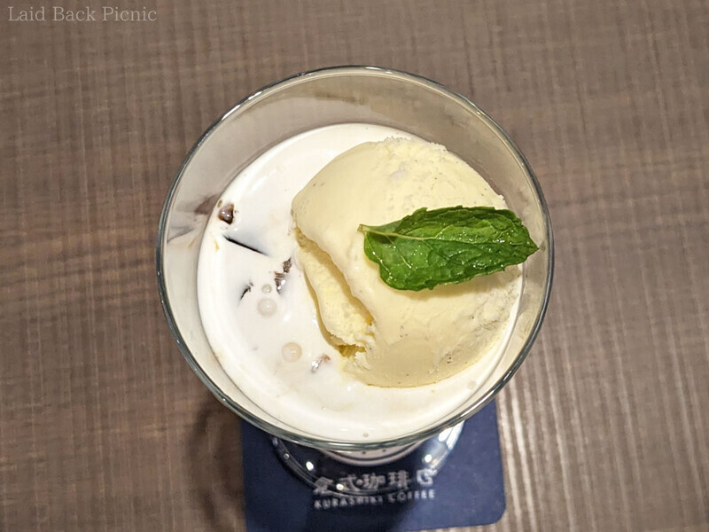 コーヒーミルクが表面を覆い、その上にバニラアイス、ミントの葉。