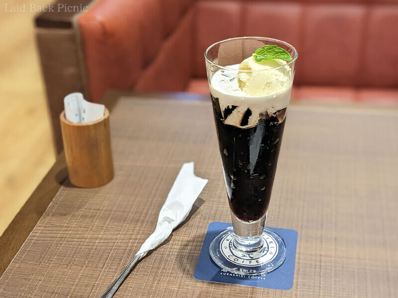三角錐のパフェグラスに珈琲ゼリーがたっぷり、その上にコーヒーミルクとバニラアイス。