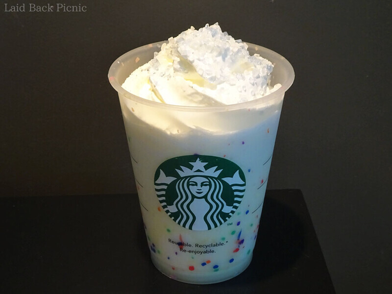 全体い白いフラペチーノ、トッピングには白と青のキラキラシュガー。