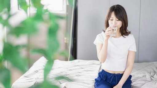 起床時に常温の水を飲む女性