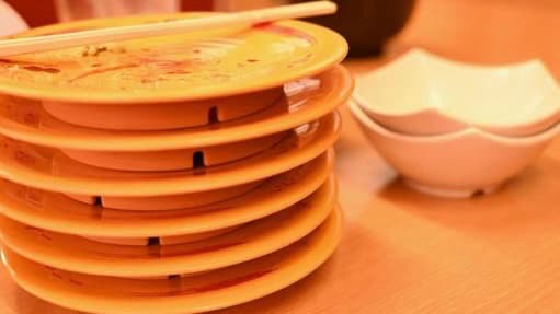 積み上げられた回転寿司の皿の画像