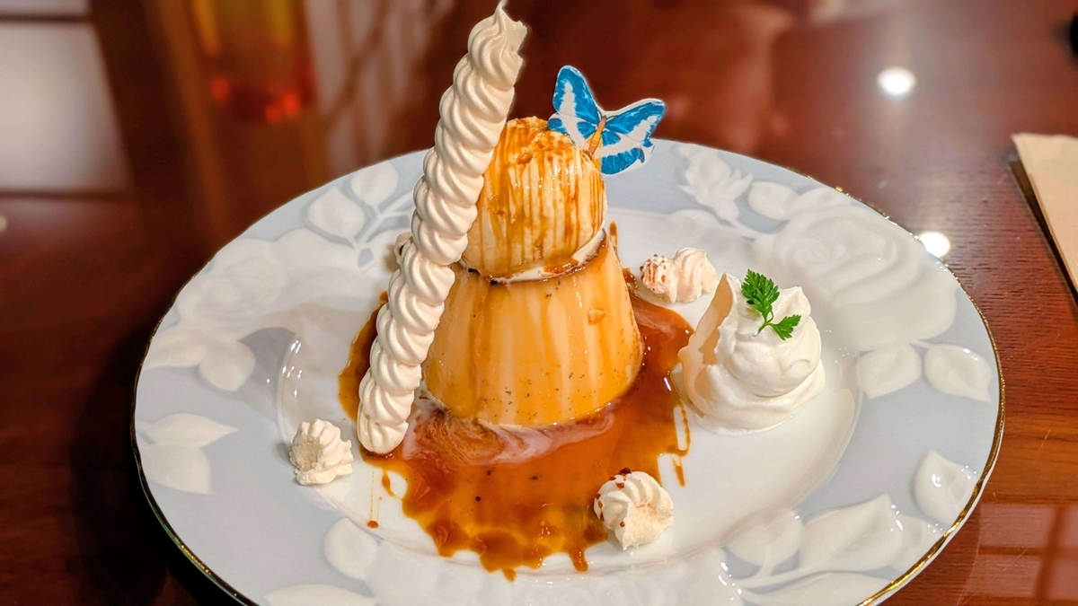 焦がしカラメルの濃いプリン。ゴージャスな盛り付けはまるで誕生日ケーキのよう。砂糖菓子が添えられています