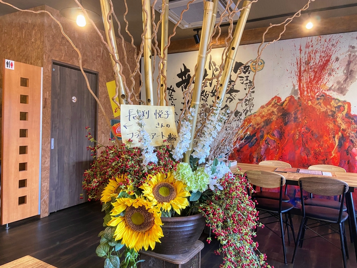 壁面には長渕剛 大迫力の詩画『桜島』つなぎ無し牛肉100％の炭火焼きの