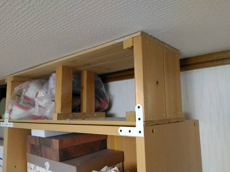 本棚と天井の間に木枠をはめ込み固定 本棚と天井の間にはめこんだ手作り木枠