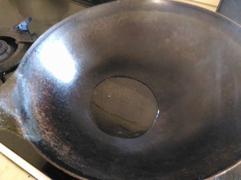 使い込んだ中華鍋に、油をたっぷり。 中華鍋で油を加熱。