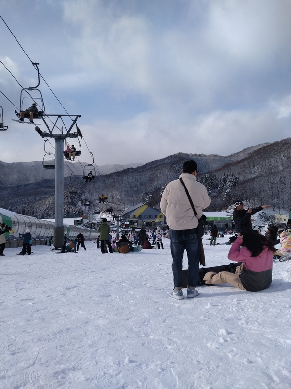 板をつけたままゲレンデに座る人々