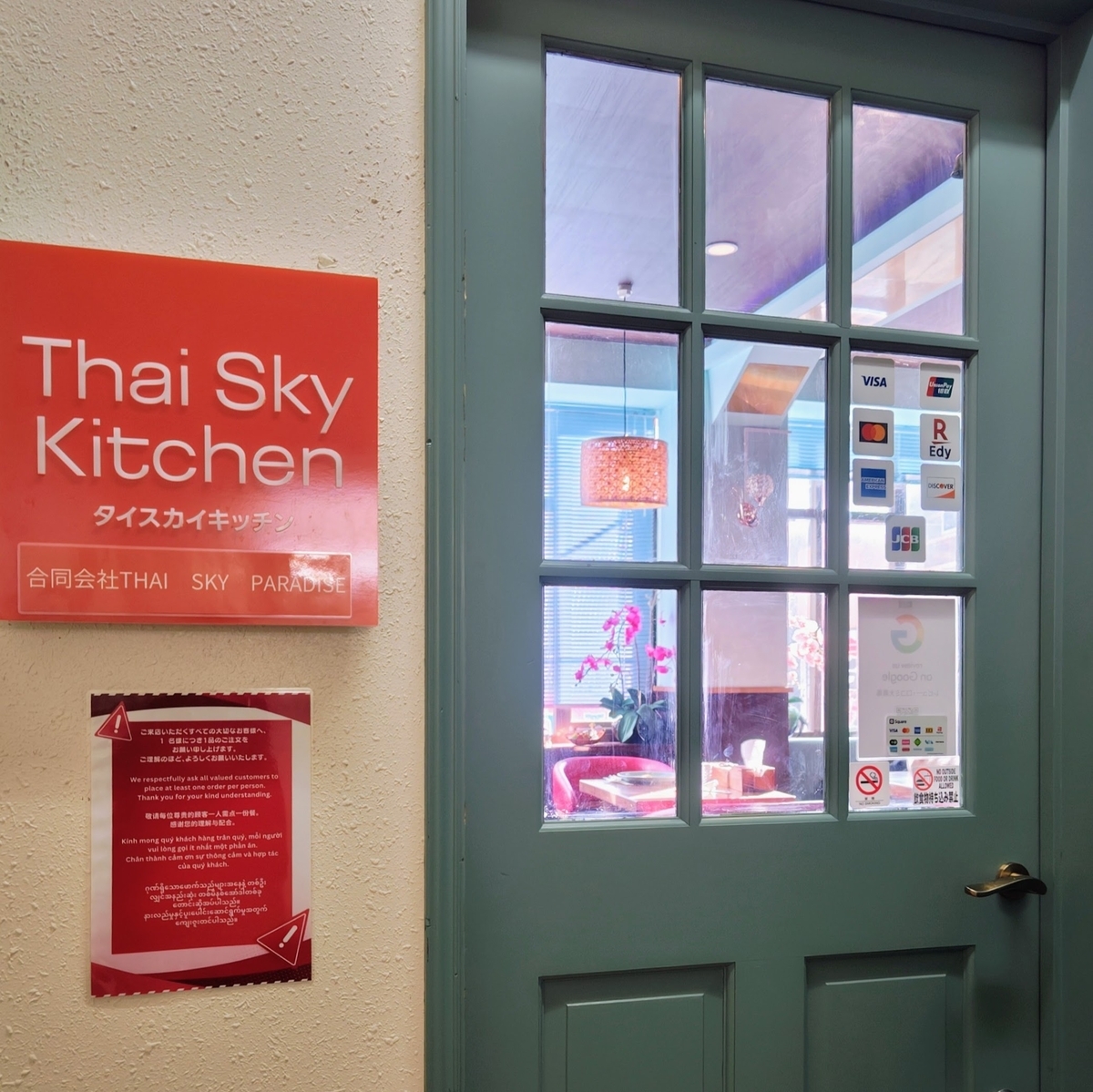 タイスカイキッチンの入口ドア。キャッシュレス決済の案内が貼られている