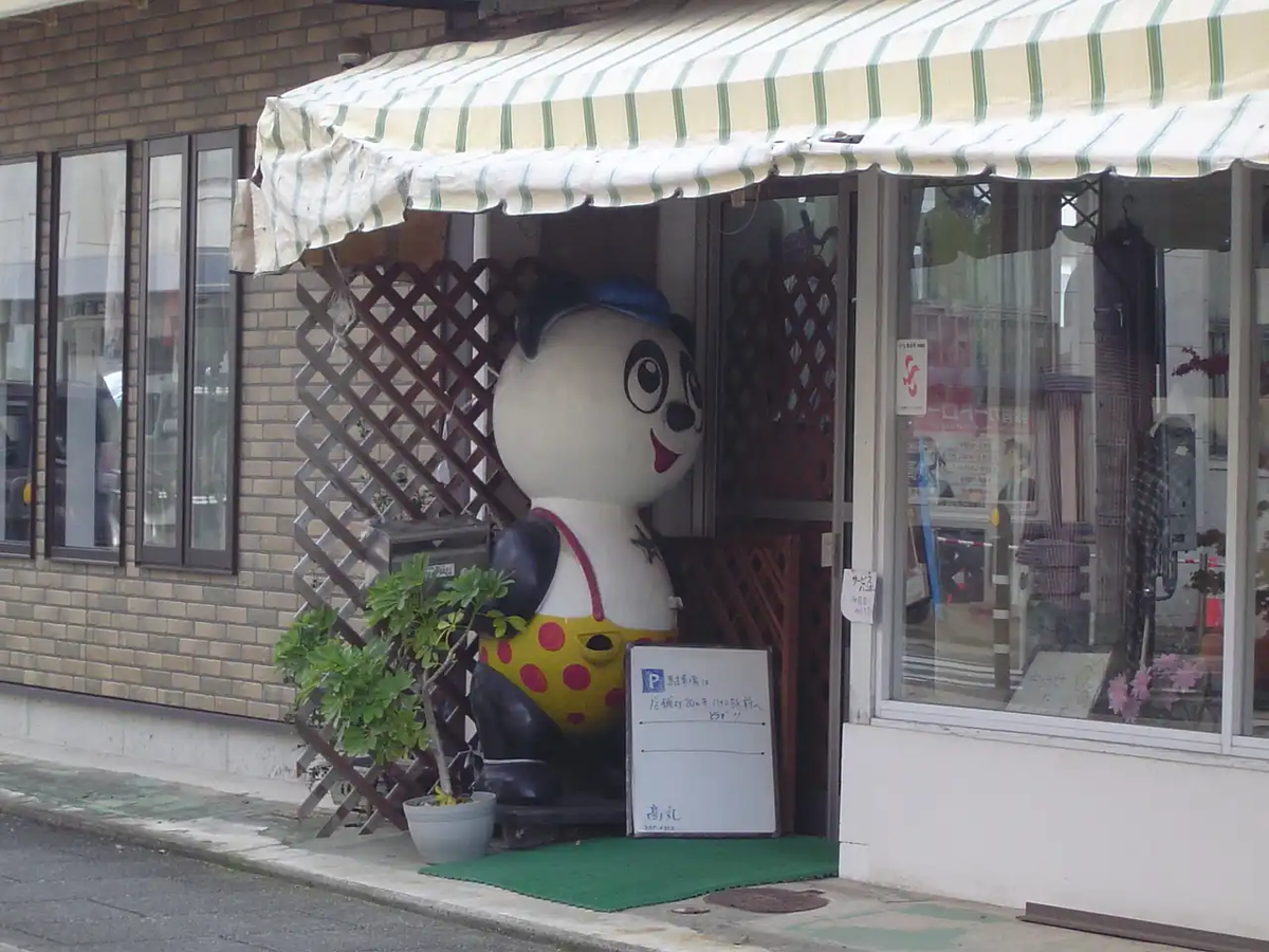 レトロな看板キャラクターが店先にある衣料品店の外観