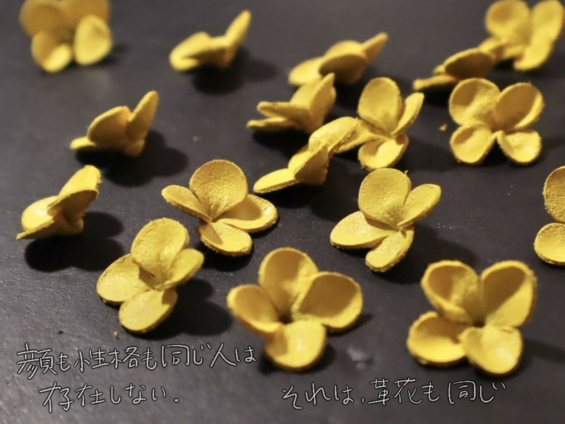 さまざまな形に成形された革の菜の花が並ぶ。「顔も性格も同じ人は存在しない。それは、革花も同じ」というメッセージ付き。