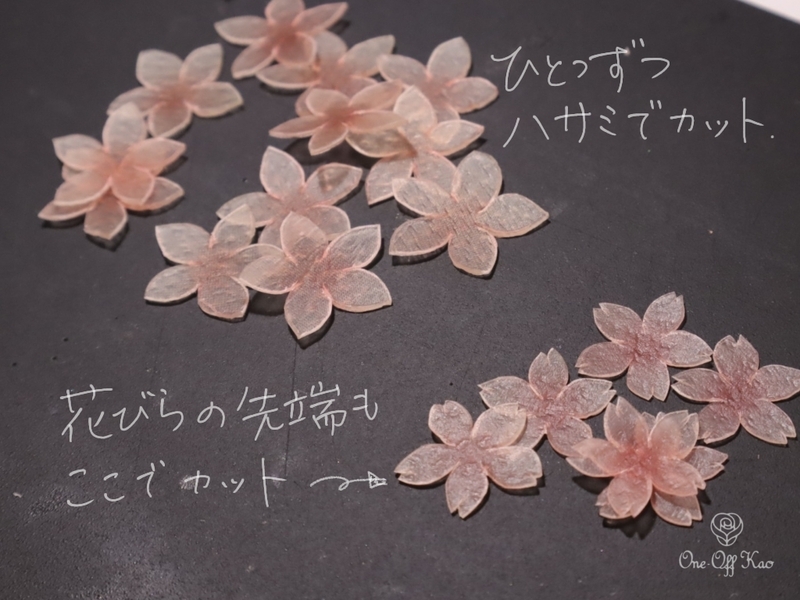 桜の形にカットされた生革。黒い背景の上に花びらが並べられている。