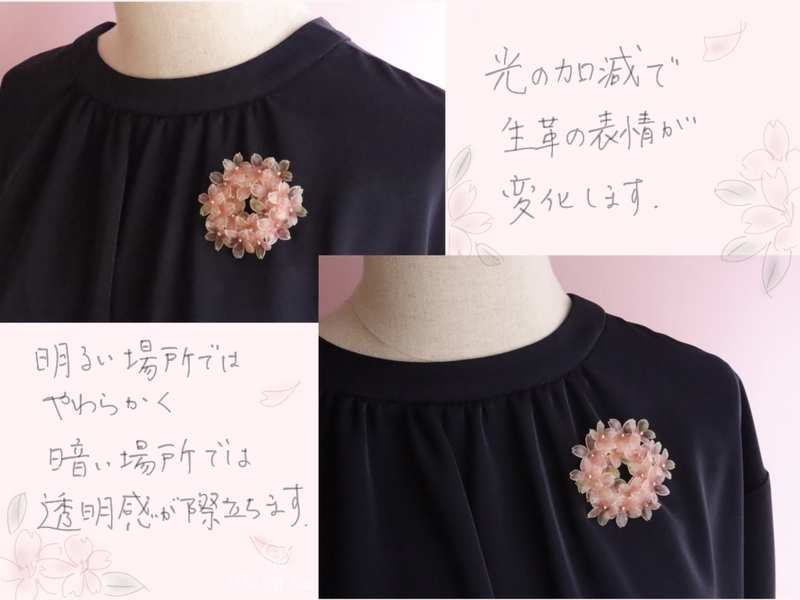 ネイビーのトップスに着用した生革の桜ブローチ。明るい場所と暗い場所での違いを比較。
