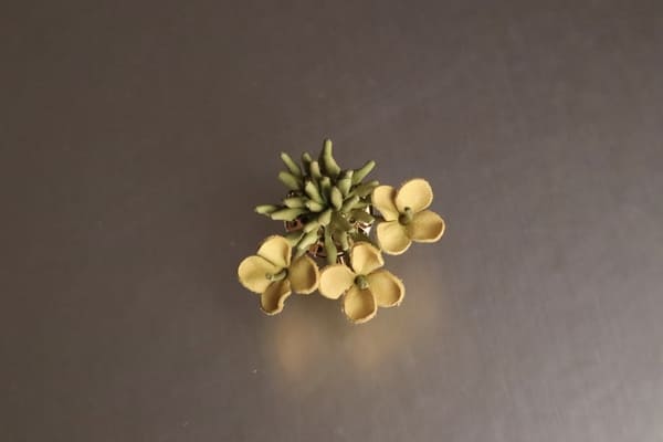 菜の花の革花イヤリング。黄色い花と緑のつぼみがリアルに再現されたデザイン。
