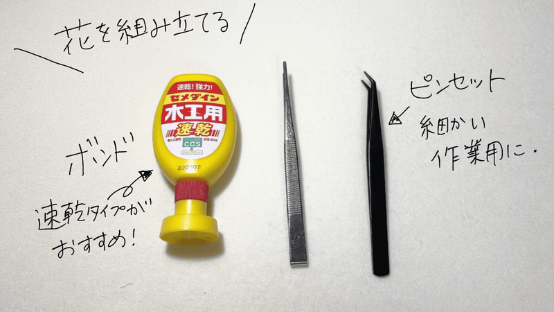 革花を組み立てるための道具。速乾タイプの木工用ボンドと、細かい作業用のピンセット2種類（先の細いタイプ）が並んでいる。