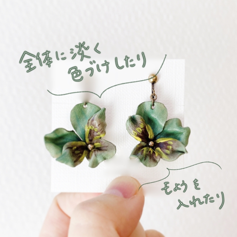 アクリル絵の具で濃淡をつけて着色したビオラ風の革花イヤリング。グリーンを基調に、中心に黄色のアクセントを加えたナチュラルな色合い。