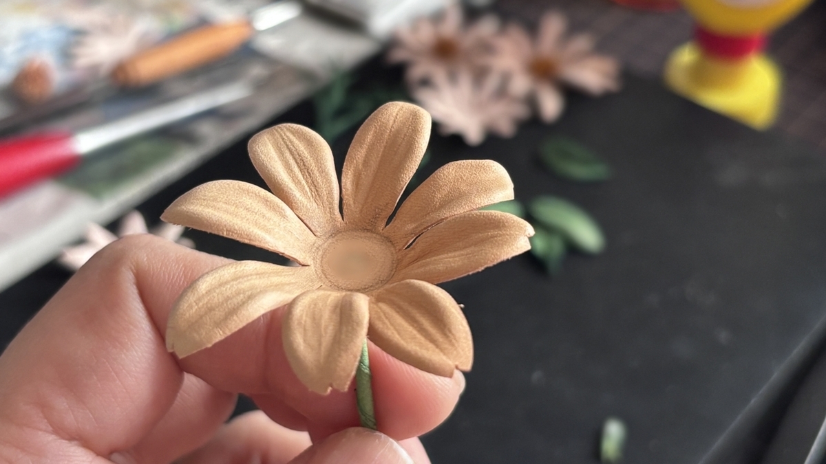 完成直前のマーガレットの革花。花芯はつけず、ナチュラルな仕上がりで春らしさを演出。