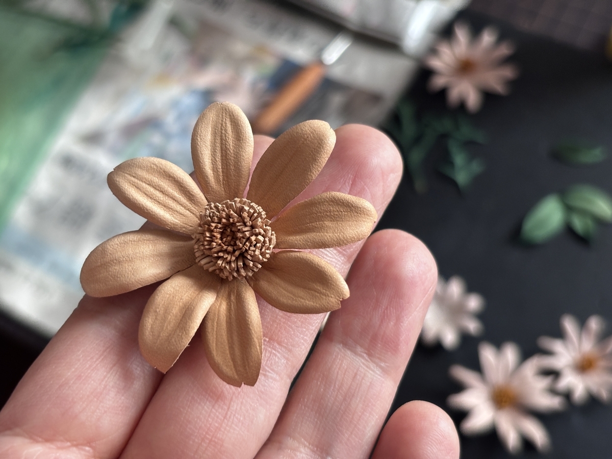 手のひらにのせた完成形のマーガレット。優しい曲線の花びらと繊細な花芯が魅力。