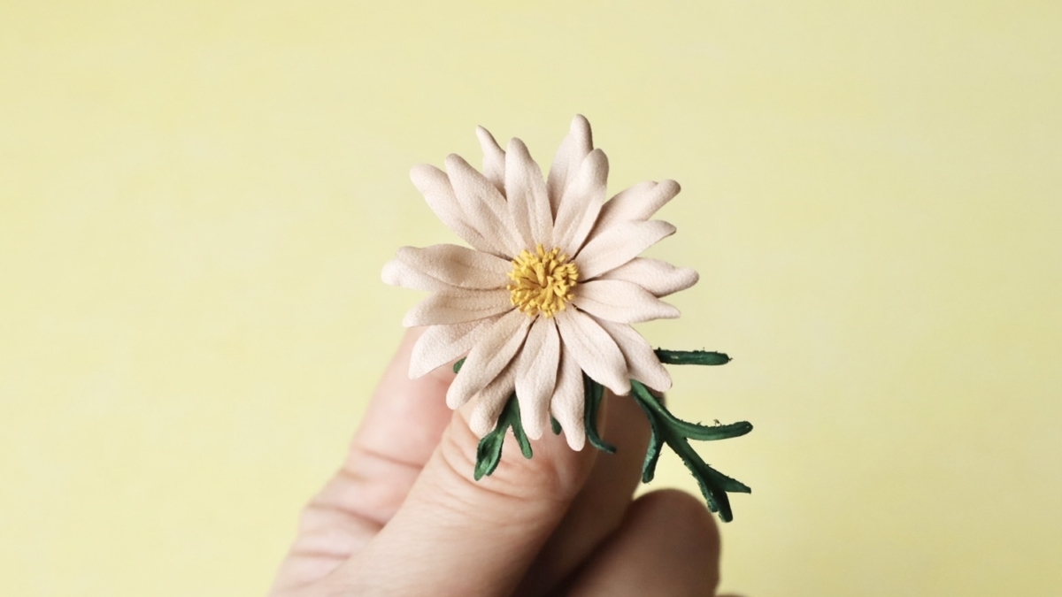 ★3型紙で作ったマーガレットのタックピン。花びらの重なりと立体感が特徴の革花作品。