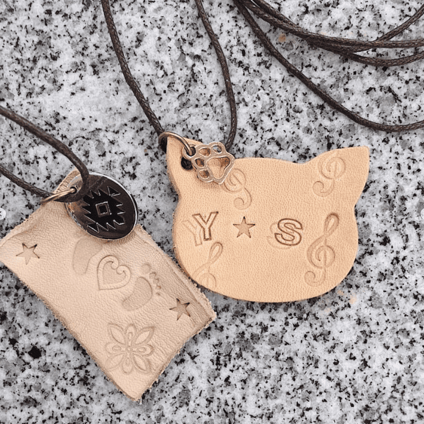 猫・長方形の革に刻印を打った作品。それに紐を通したネックレス。