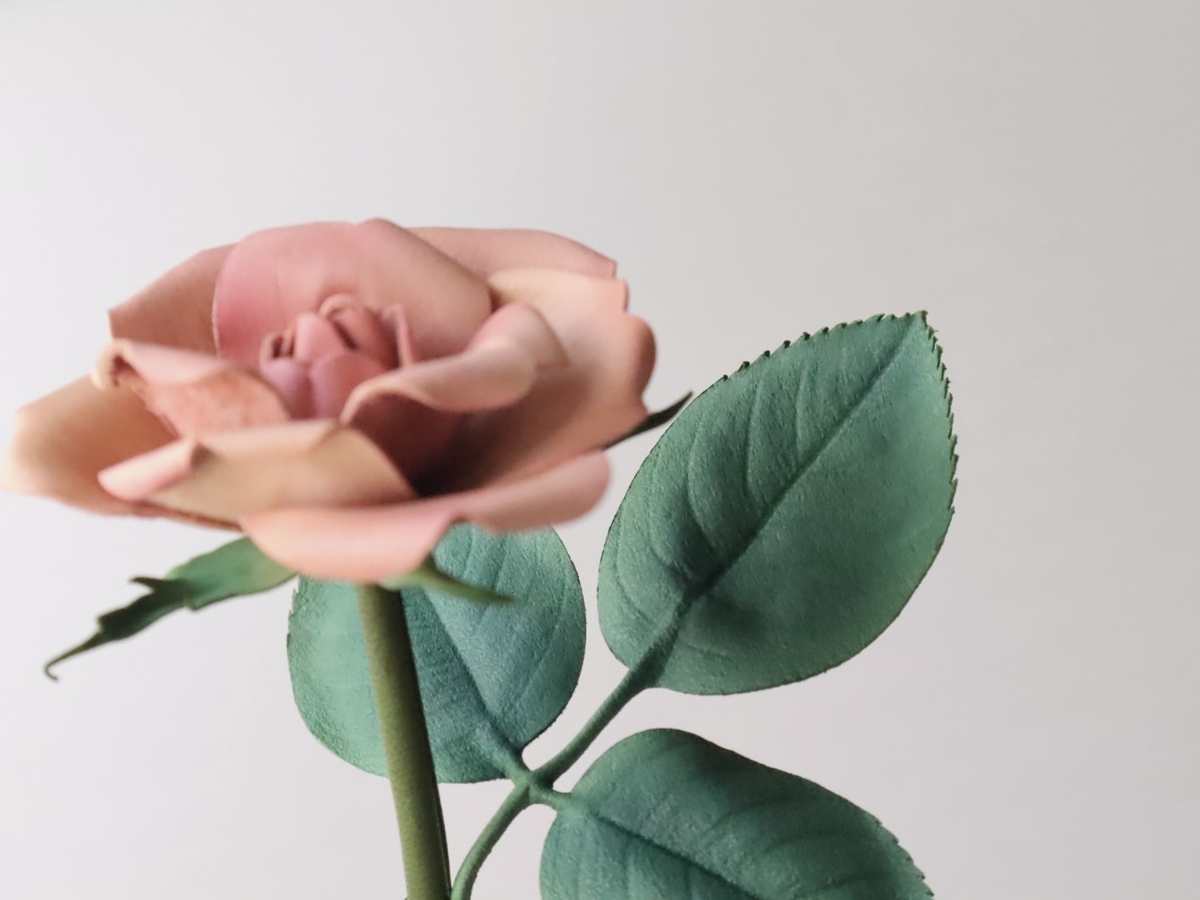 革で作られた一輪のバラ。葉っぱがより見える構図