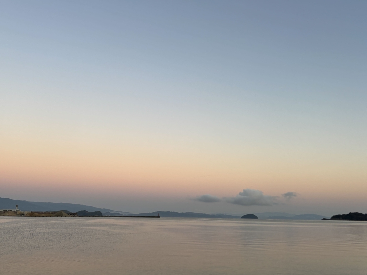 新しい始まりを感じる、静かな海と朝焼けの空