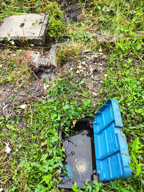 【水没した水道給水栓とメータ（手前）、奥は排水溝で雨水で一杯】