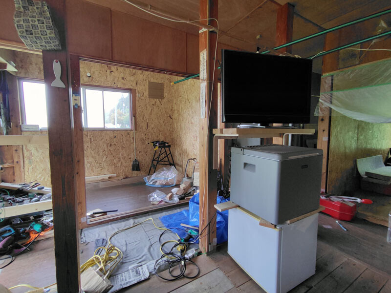 【柱にテレビ置棚を付け、その下は冷蔵庫の仮置き場】