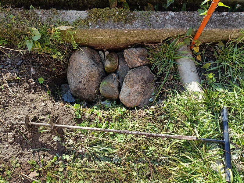 【11日午後・日南町：螺旋穴掘り器（手前）と石で埋めた「排水浸透桝」】