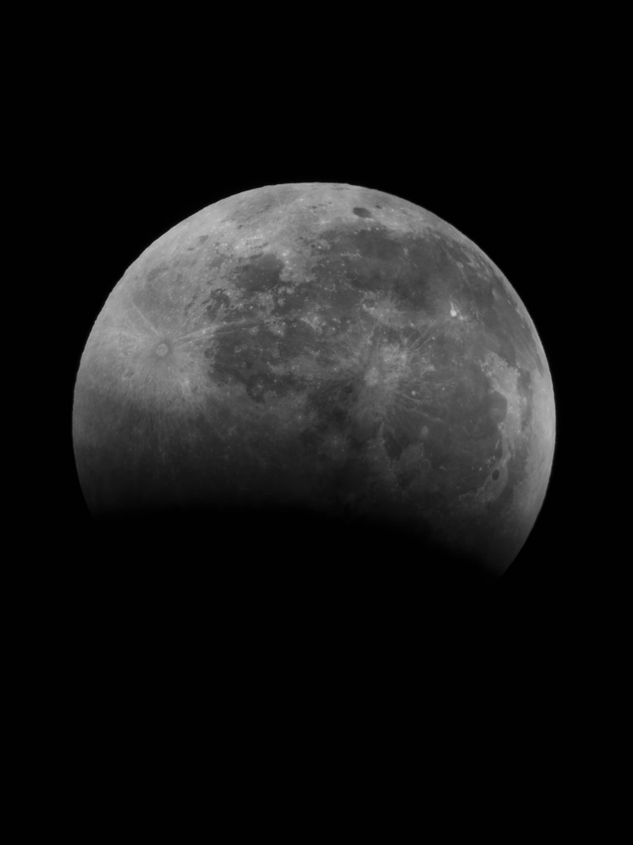皆既月食の序盤、下側から影に入り始めたモノクロの月。夜の観察と試行錯誤のスタートを示す一枚。