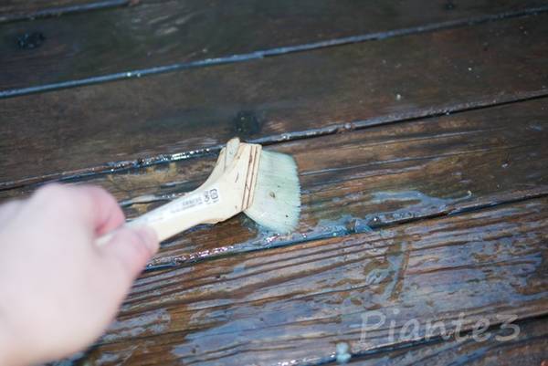 オスモウッドリバイバージェルを刷毛で木材に塗っている