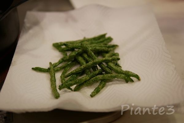 揚げたインゲン豆の油をきっている