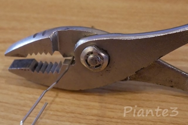 プライヤーで針金を切断している写真