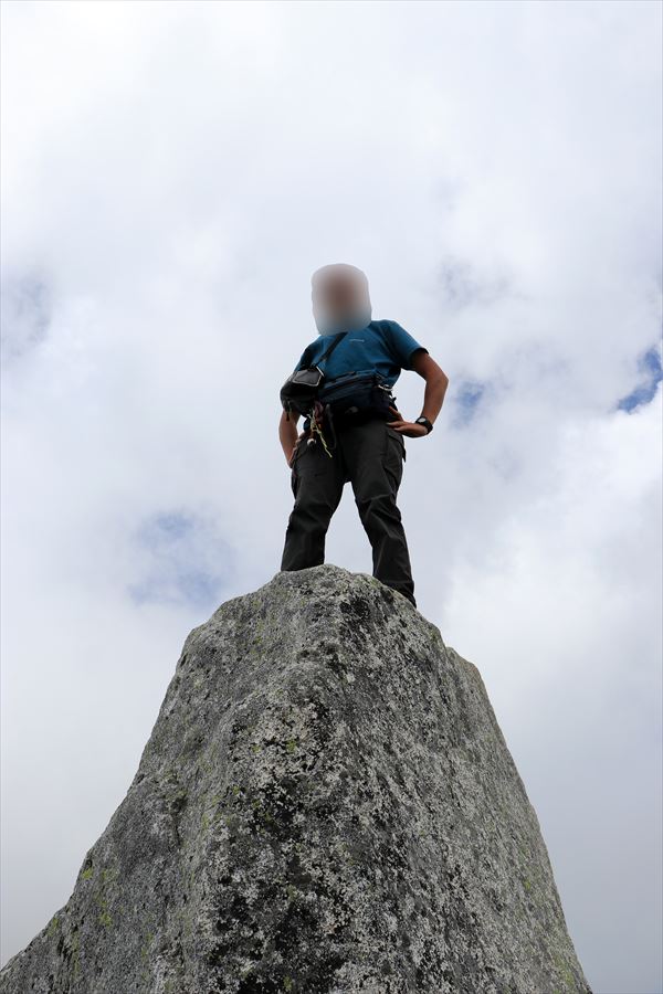 宝剣岳の山頂の岩の上に立つ人（中央アルプス）
