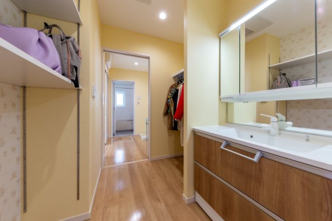 玄関近くに設置し、収納棚を備え付けた洗面室／注文住宅実例