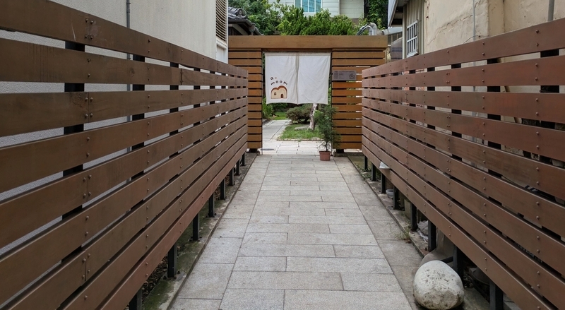 路地を抜けた奥に佇む、通りからは見えにくい隠れ家的な雰囲気のカフェ外観。