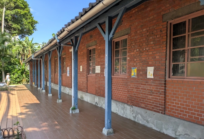 屋根を支える木製の柱とレンガ造の外壁が特徴的な建物構造。