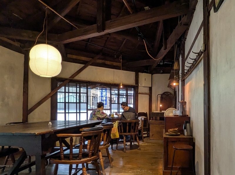 テーブル席の上部に見える日本建築的な小屋組の天井構造。